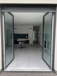 ein großes Glasfenster eines Zimmers mit einem Tisch und Stühlen in der Unterkunft Traumhafte Wohnung am Bodensee in Staad