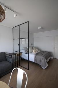 a bedroom with a bed and a chair and a couch at Nuevo estudio al mar con cochera in Mar del Plata