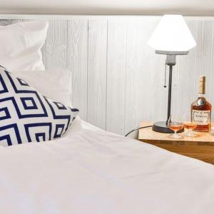 a bed with a lamp and two glasses of wine at Hotel & Restaurant Utspann Schafflund in Schafflund