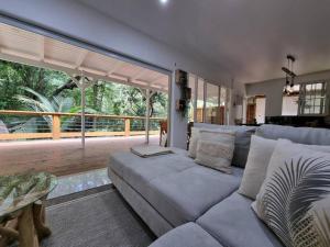 a living room with a couch and a large window at L'ilet Paradise in Pointe-Noire