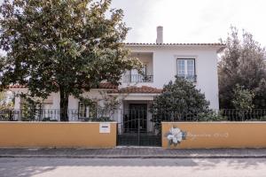 a white house with a tree in front of it at Magnolia B&B in Leiria