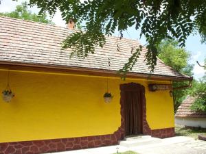 a yellow house with a brown door on it at Apartment Bodza in Tompa