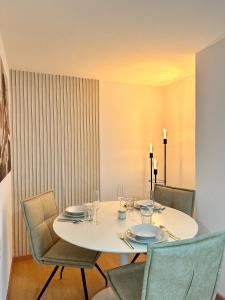 mesa de comedor con sillas, mesa blanca y sillón en Ferienwohnung zwischen Hafen und Stadt, en Bregenz