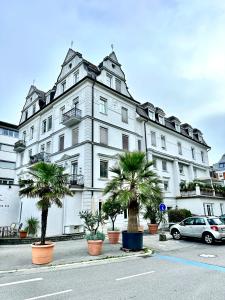 a large white building with palm trees in front of it at Ferienwohnung zwischen Hafen und Stadt in Bregenz
