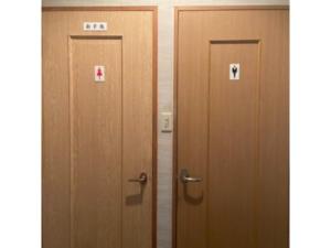 Asobiyahouse Iki - Vacation STAY 30418v في إكي: بابين خشبيين مع وجود لافتات عليهم في الغرفة