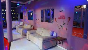 TSANKARA في Oiapoque: غرفة معيشة مع أرائك وأزهار مرسومة على الحائط