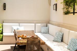 a table and chairs with a couch on a patio at Iris Skiathos in Skiathos Town +19 photos
