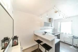 a white kitchen with a counter and a sink at Nice 34 m near La Confluence in Lyon