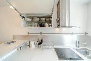 a white kitchen with a sink and a counter at Nice 34 m near La Confluence in Lyon