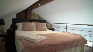 ein Schlafzimmer mit einem großen Bett mit Kissen in der Unterkunft O Beiral da Anastácia in Marco de Canavezes