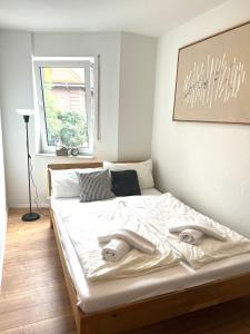 1 dormitorio con 1 cama con sábanas blancas y ventana en japandi für 2 I nahe Mannheim, Schwetzingen, en Brühl