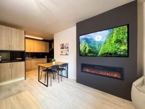 eine Küche mit einem Tisch und einem TV an der Wand in der Unterkunft Espectacular Apartamento Con Vistas En Escaldes - 10min Caminando Al Centro - Parking Gratis in Escaldes-Engordany