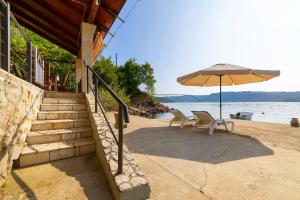 a patio with two chairs and an umbrella at Apartment Haus Kicer in Kraljevica