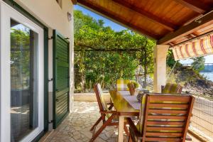 a wooden table and chairs on a patio at Apartment Haus Kicer in Kraljevica +26 photos