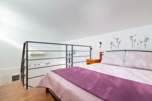a bedroom with a bed with a purple blanket at Apartment Haus Kicer in Kraljevica