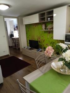 een woonkamer met een tafel en een groene muur bij La Petite Maison in Aci Castello