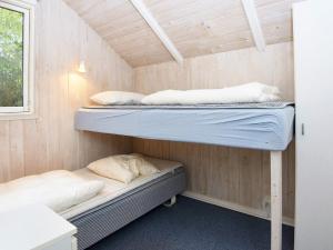Cette chambre comprend 2 lits superposés et une fenêtre. dans l'établissement Holiday home Fårvang VII, à Fårvang