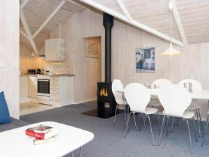 une chambre avec une table et des chaises blanches ainsi qu'une cuisine dans l'établissement Holiday home Fårvang VII, à Fårvang