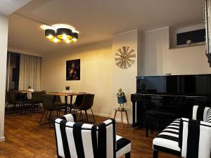 a living room with a table and a piano at Hotel Unterfeldhaus in Erkrath