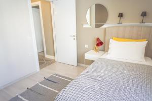 a bedroom with a bed with a yellow pillow and a mirror at Downtown Oasis - Spacious Modern 3-BR Flat near Beachpark in Antalya +33 photos