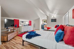 a bedroom with a large bed with red and blue pillows at Game On Fayetteville's Premiere Entertainment-Packed Getaway in Fayetteville