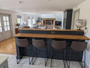 cocina y sala de estar con barra con taburetes en Fairfields Country House, en Moira