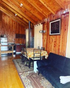sala de estar con sofá azul y mesa en Cabañas Armonía del Ranco, en Lago Ranco
