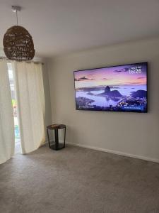 a living room with a flat screen tv on the wall at The cosy beach House in Llanelli