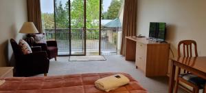 a living room with a bed and a sliding glass door at Methven Motel & Apartments in Methven