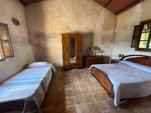 a bedroom with two beds and a mirror at Casa Rural La Peralosa in Piedrabuena