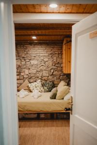 una cama en una habitación con una pared de piedra en Monolocale Marino in centro storico, en Trieste
