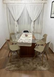 una mesa de cristal y sillas en una habitación con ventana en Casa, en Itu