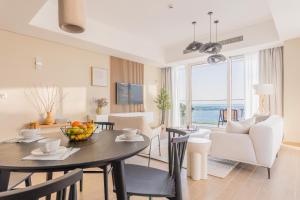 a dining room and living room with a table and chairs at Paradise Holiday Home with Private Beach Access 605B2 in Abu Dhabi