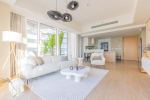 a living room with a white couch and a table at Paradise Holiday Home with Private Beach Access 605B2 in Abu Dhabi