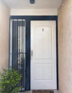 una puerta blanca con un marco negro junto a un edificio en Alojamiento V&M Mendoza en Mendoza