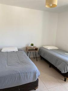 1 dormitorio con 2 camas y mesa con lámpara en Alojamiento V&M Mendoza en Mendoza