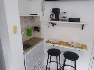 uma cozinha com dois bancos de bar e um balcão em Mini estúdio Pão de Açúcar no Rio de Janeiro
