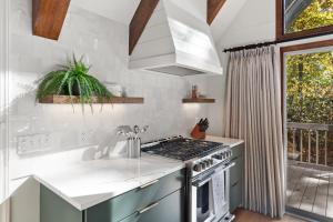 a kitchen with a stove top oven next to a window at A-Frame on Balsam in Valle Crucis