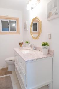 Baño blanco con lavabo y espejo en Cozy Private Room-Your Perfect place in Hamilton, en Hamilton