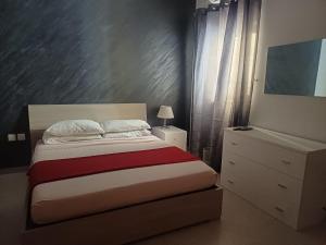 1 dormitorio con 1 cama con colcha roja y blanca en Modern Private Rooms in an apartment, en St Paul's Bay