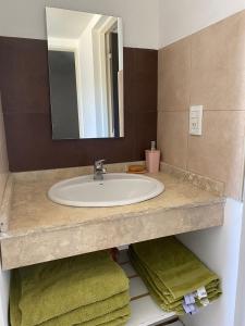 y baño con lavabo, espejo y toallas. en Alojamiento V&M Mendoza en Mendoza