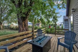 two chairs and a bench on a deck with a tree at The Davey Retreat in Buffalo