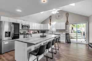 a kitchen with white cabinets and a large island with bar stools at The Davey Retreat in Buffalo