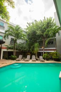 una piscina frente a un edificio con sillas y árboles en Hotel Nacional Merida, en Mérida