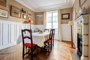 ヌイイ・シュル・セーヌにあるAppartement Panel - Welkeysのダイニングルーム(テーブル、椅子、暖炉付)