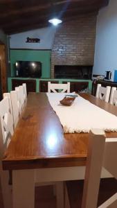 una mesa de comedor con sillas blancas y una mesa de madera con en Mi casa, tu casa. Entre Plottier y Neuquen. en Neuquén