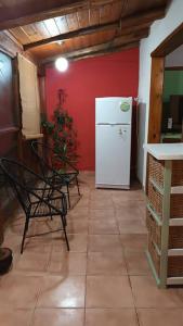 een keuken met een witte koelkast en een rode muur bij Mi casa, tu casa. Entre Plottier y Neuquen. in Neuquén