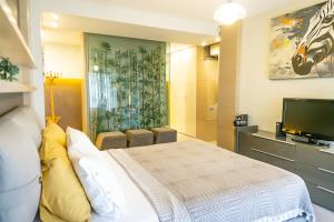 a bedroom with a bed and a flat screen tv at Downtown Oasis - Spacious Modern 3-BR Flat near Beachpark in Antalya