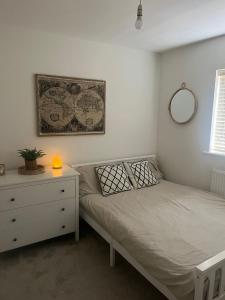 a bedroom with a bed and a dresser and a mirror at The cosy beach House in Llanelli