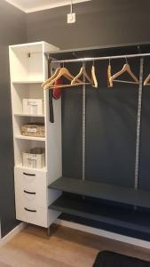 um armário com prateleiras brancas e cabides num quarto em Leilighet i enebolig på Valderøya ved Ålesund em Ytterland